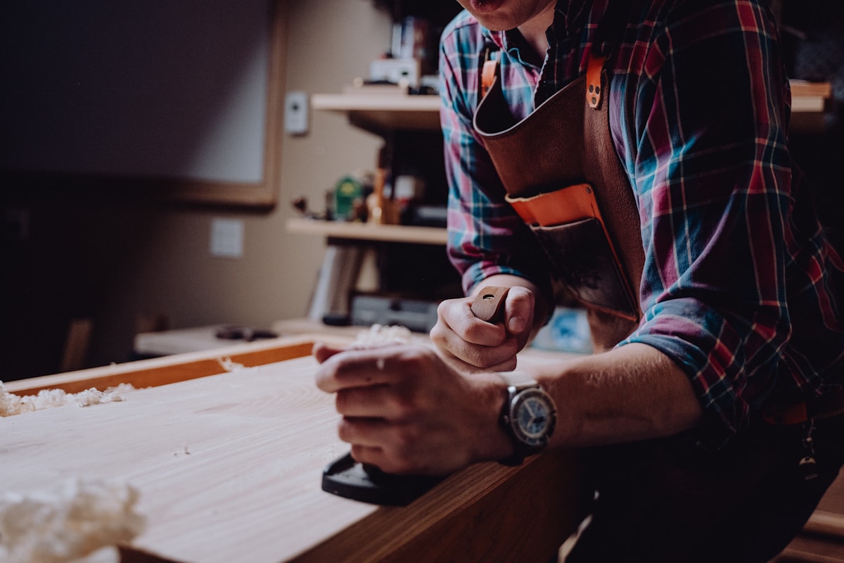 Jérémie Gigaud, artisan d'Allo Jerem, façonnant une pièce de bois à l'établi