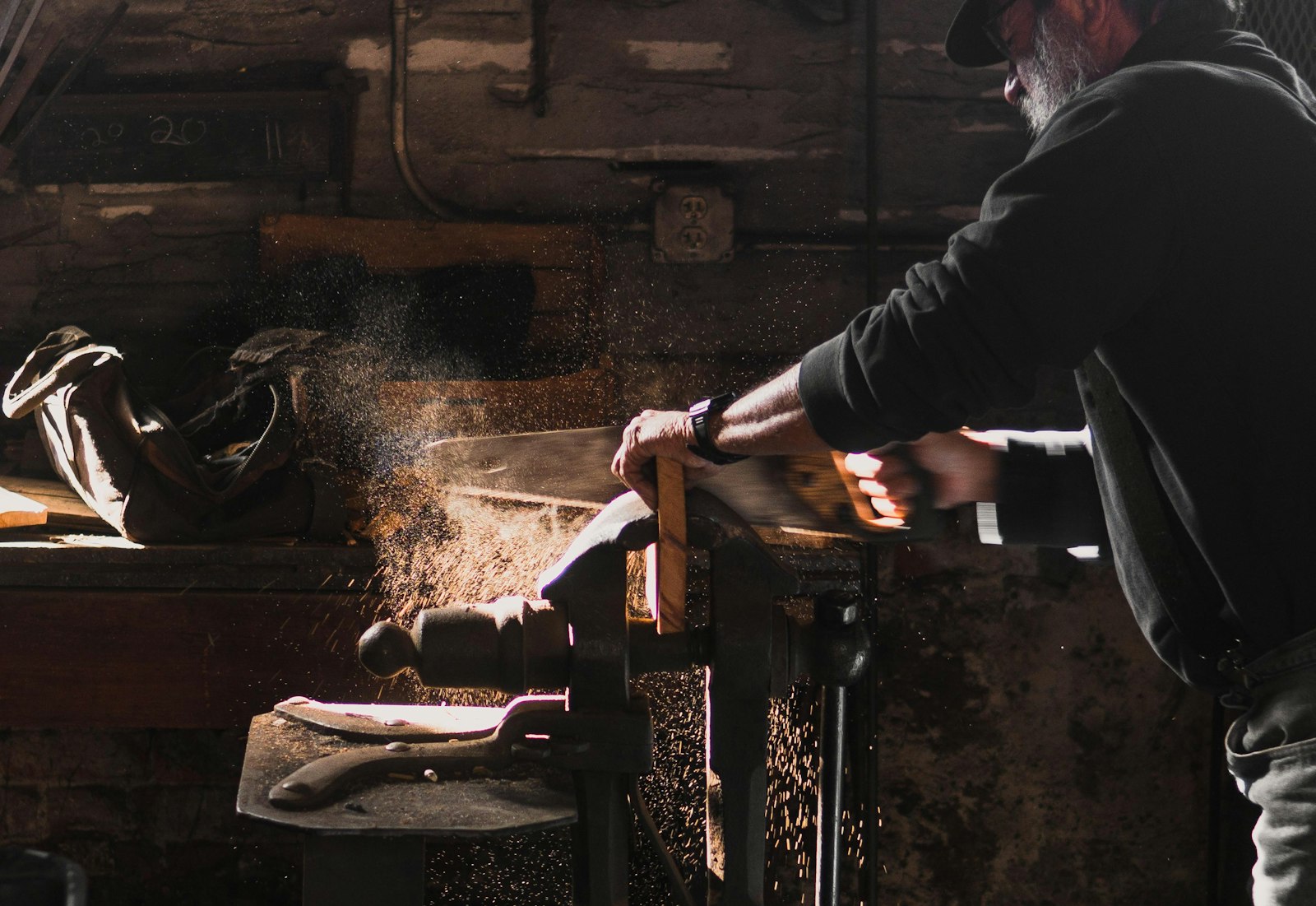 Artisan au travail dans son atelier, sciant une pièce de bois